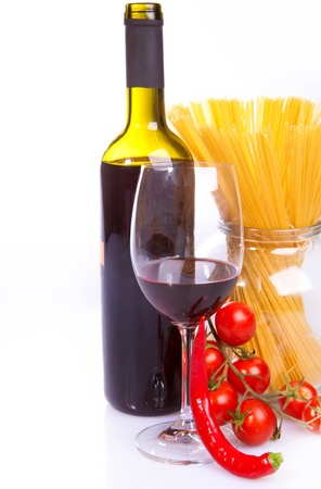 Glass of red wine near italian spaghetti and vegetables for pastaの写真素材