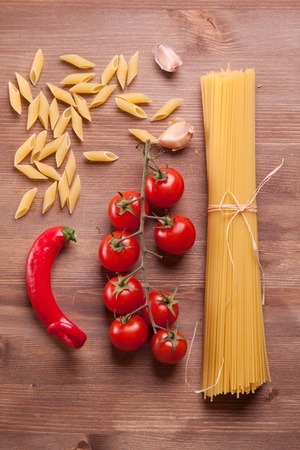 Composition of tow kind of pasta, chili pepper, onion and tomatoの写真素材