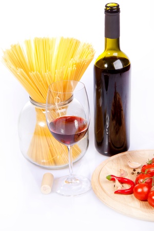 Glass of red wine near italian spaghetti and vegetables for pastaの写真素材