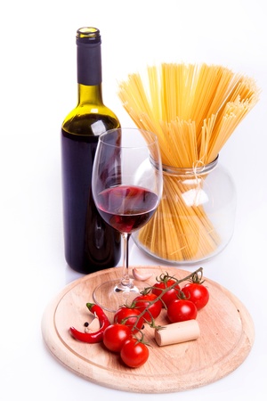 Glass of red wine near italian spaghetti and vegetables for pastaの写真素材