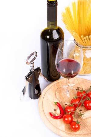 Glass of red wine near italian spaghetti and vegetables for pastaの写真素材