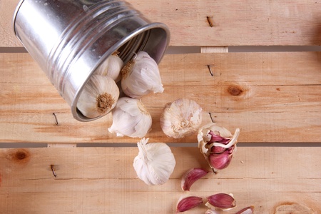 Garlics from pail on old woodの写真素材