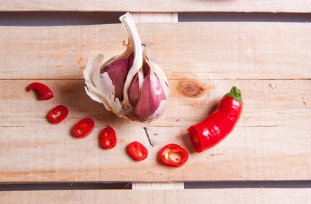 Garlic and red hot chili pepper on wooden deskの写真素材