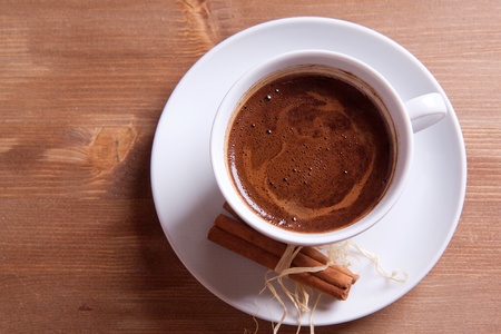 Cup of black coffee with cinnamon on a wooden tableの写真素材