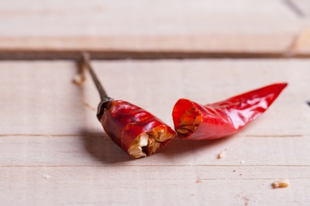 Breaking red hot chili pepper on the wooden deskの写真素材