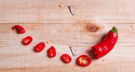 Sliced red hot chili pepper on wooden deskの写真素材