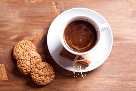 White cup of black coffee with cinnamon and cookiesの写真素材