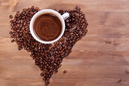 White cup of black coffee with coffee beans as a heartの写真素材