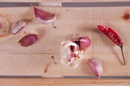 Garlic and dry pepper on old woodの写真素材