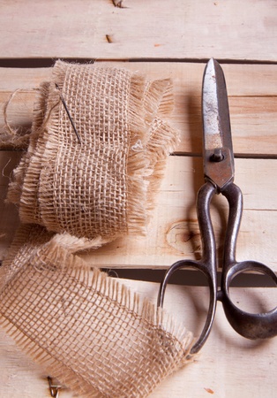Old scissors, cottons and needle on wooden deskの写真素材