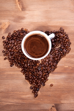 White cup of black coffee with coffee beans as a heartの写真素材