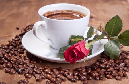 White cup of black coffee with coffee beans and red roseの写真素材