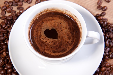 White cup of black coffee with little heart on coating. For themes like love, valentine's dayの写真素材