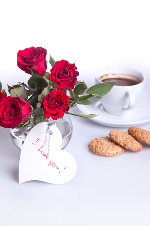 breakfast with cup of coffee, cookies and bunch of red rosesの写真素材
