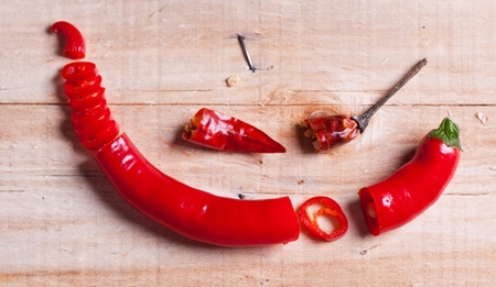 Sliced red hot chili pepper and little dry pepper on wooden deskの写真素材