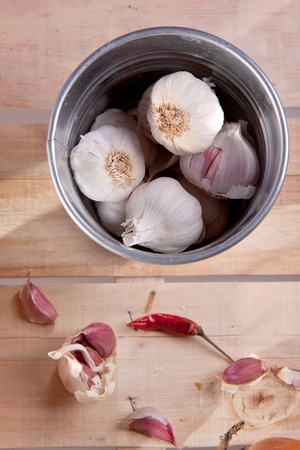 Garlics in pail on old woodの写真素材