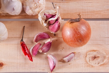 Garlics and onion on old woodの写真素材
