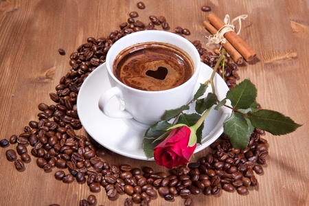 White cup of black coffee with coffee beans and red roseの写真素材