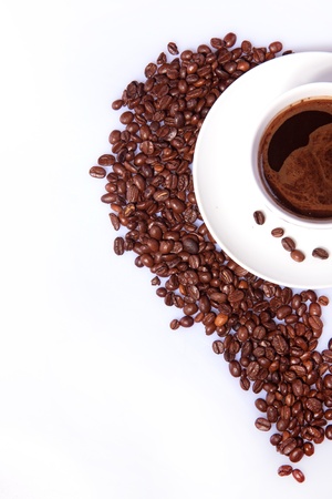 White cup of black coffee with coffee beans as half of heart over whiteの写真素材