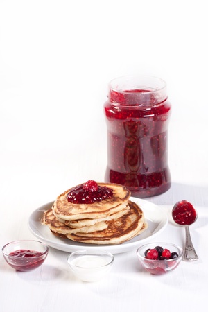 Breakfast with pancakes, fresh berries and strawberry jam over whiteの写真素材