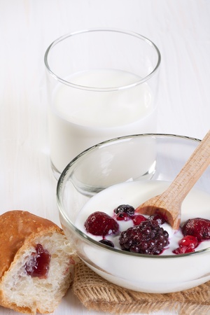 Breakfast with croissant, fresh berries, milk and plate of yoghurtの写真素材