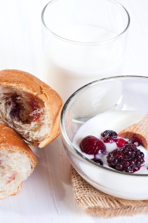 Breakfast with croissant, fresh berries, milk and bowl of yogurtの写真素材