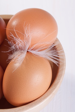 Bowl of eggs and white featherの写真素材
