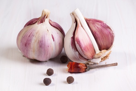 Garlic and pepper on white tableの写真素材
