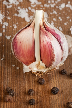 Garlic with salt and peppr on wooden tableの写真素材