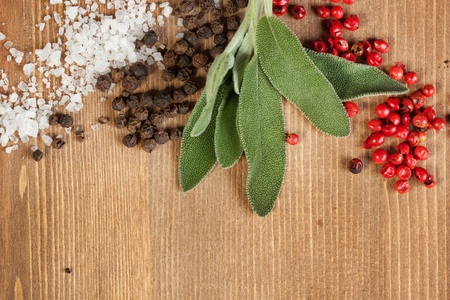 Border of salt and pepper's mix with fresh herb on the wooden deskの写真素材
