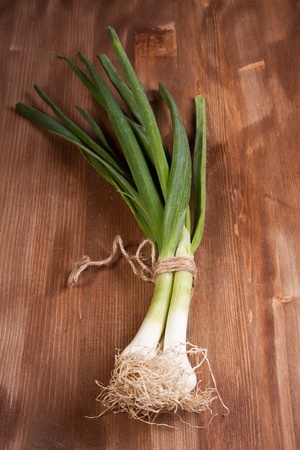 Green Onions sheaf on wooden tableの写真素材