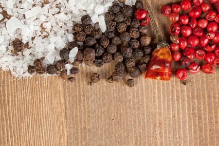 Border of salt and pepper's mix on the wooden deskの写真素材