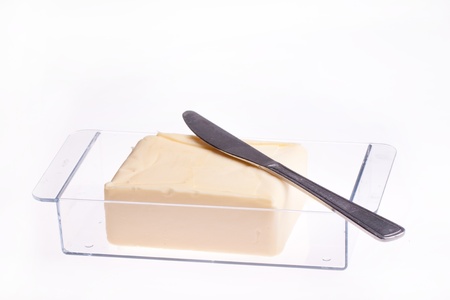 Open Block of Butter in butter dish with knife isolated over whiteの写真素材