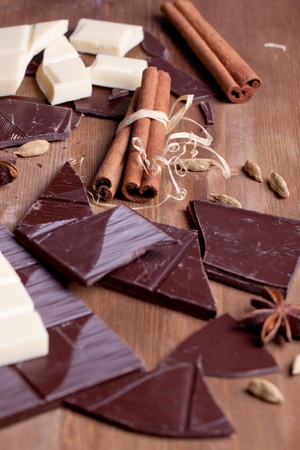 Chopped black and white chocolate with cinnamon, anise and cardamom on wooden tableの写真素材