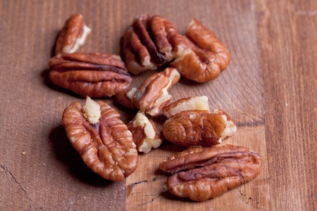 Bunch of pecan nuts on wooden background