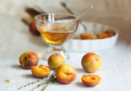 Fresh apricots with cup of honey on white wooden tableの写真素材