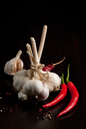 Bunch of garlic, red hot chili pepper and fresh thyme on black tableの写真素材