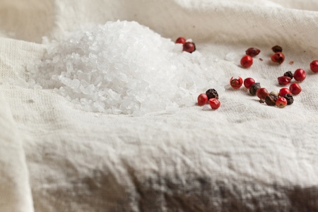 Close-up of sea salt and pepper on white clothの写真素材