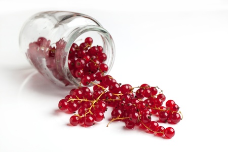 Glass jar with wet red currant isolated over whiteの写真素材