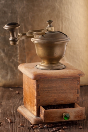 old-fashioned coffee grinder and roasted coffee beans on brown wooden table の写真素材