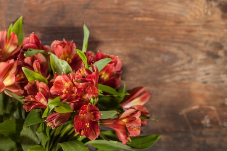 Bouquet of beautiful red lily on wooden textured backgroundの写真素材
