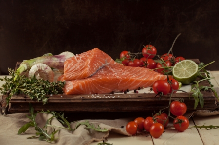 salted fresh salmon fish on vintage board with vegetables and spiceの写真素材