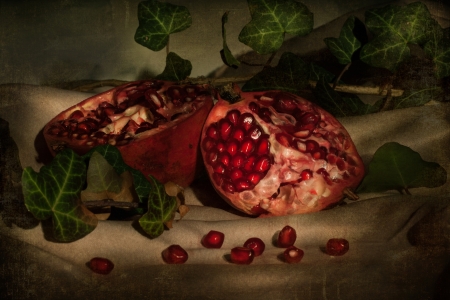 fresh juicy red pomegranate with leafs on table の写真素材