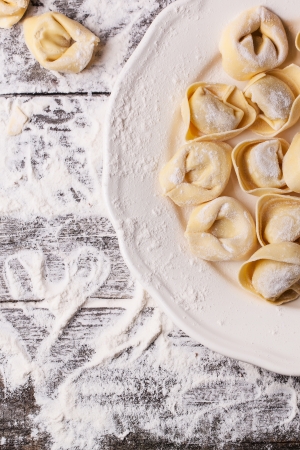 Top view on plate of homemade pasta ravioli over wooden table with flour. See seriesの写真素材
