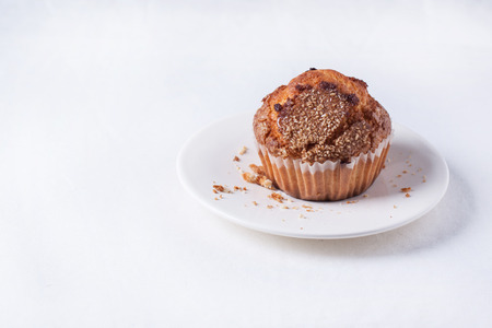 Homemade muffins with brown sugar on saucer over white textileの写真素材