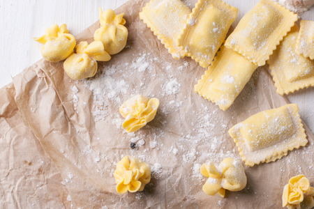 Top view on homemade pasta ravioli and perle on crumpled paper with flour.の写真素材