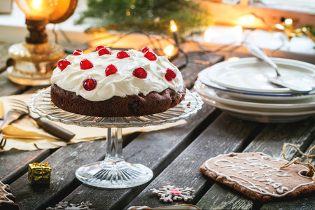 Christmas table setting with chocolate cherry cake and sugar cookies. See series