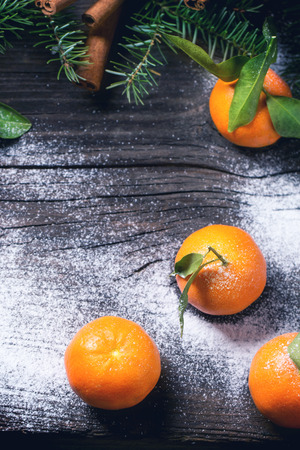 Christmas decor with tangerines, snow, cinnamon and Christmas tree. Top view.の写真素材