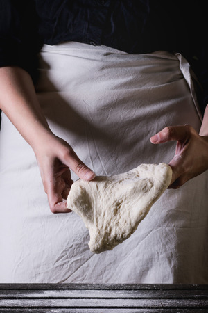 Women\'s hands making the dough for pizzaの写真素材