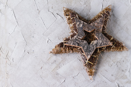 Modern Christmas decor - assortment of wooden and wire stars over gray plastered surface. Top view. With copy space at leftの写真素材